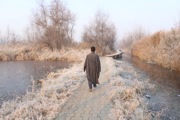A man using Koshur Sheild against intense cold, Pheran!