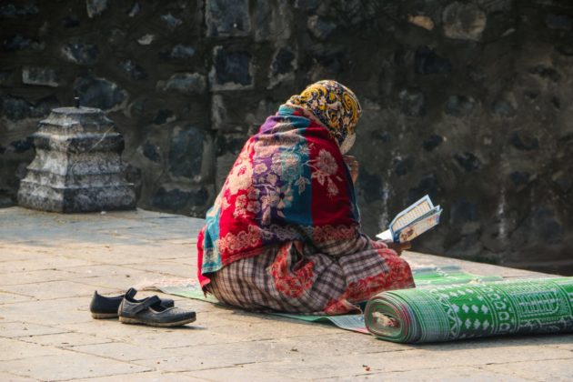 Woman reading the holy Qura'an in the compound of Khanqa-E-Maula.