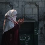 Female praying in front of the Khanqah-E-Maula.