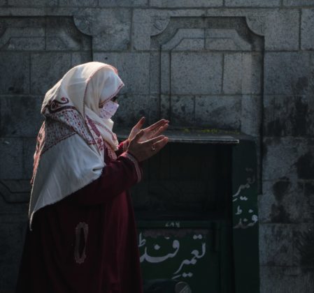 Female praying in front of the Khanqah-E-Maula.